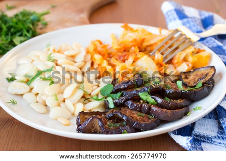Healthy vegan food. Roasted eggplants, white beand and cooked cabbage