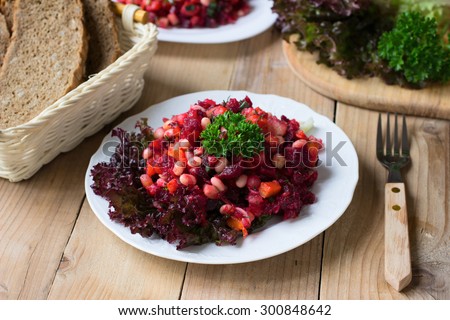Russian beetroot salad Vinegret with white beans on wooden rustic table