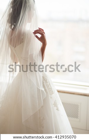 Bride looks out of the window,wedding day