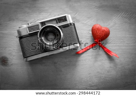 Retro Camera with red hearts on a wooden background