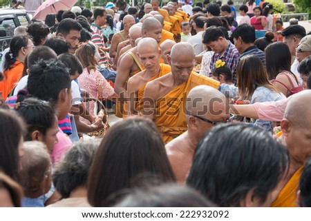 Samutprakarn, THAILAND - OCT 09 : Buddhist monks are given food offering from people for End of Buddhist Lent Day. on October 09, 2014 in Samutprakarn, Thailand.