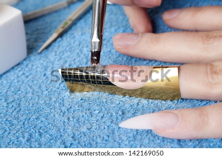 The master puts a brush a material for escalating of nails