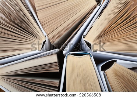 Old and used hardback books or text books seen from above. Books and reading are essential for self improvement, gaining knowledge and success in our careers, business and personal lives