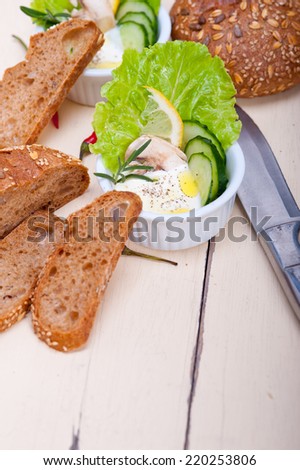 fresh organic garlic cheese dip salad on a rustic table with bread