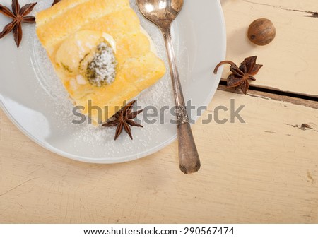 fresh homemade cream roll cake dessert and spices over white rustic wood table
