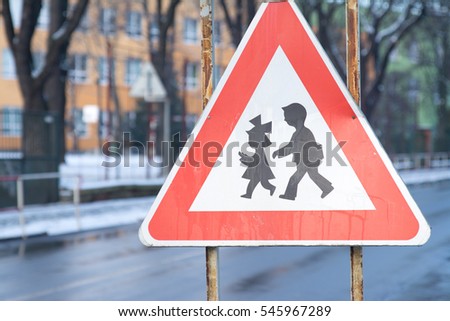Traffic sign, which is warning the driver to pay their attention to be close to school, where children can pass the road/street.
