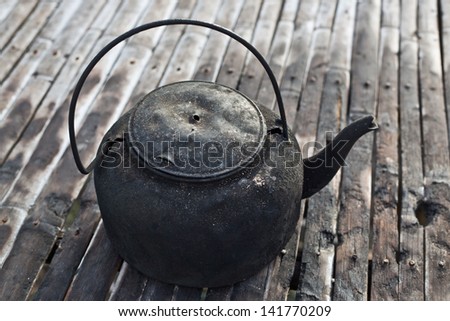 old black kettle on the bamboo floor