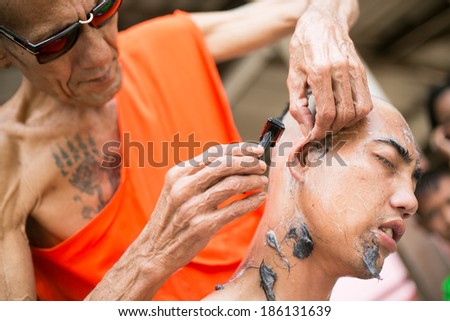 SURATTHANI, THAILAND - MARCH 23 : Thai man during a Buddhist ordination ceremony during which he becomes a monk. Monk shaved his hair and eyebrow on March 23, 2014 in Suratthani, Thailand