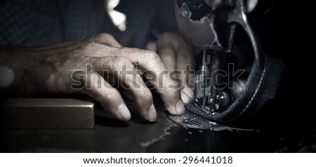 Old man\'s hands behind his sewing (vintage style)