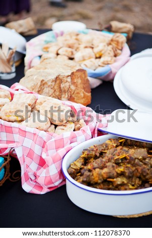 Roasted bread and mutton kebabs in dishes on a table