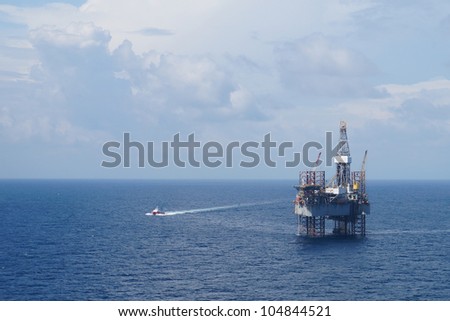 Jack up oil drilling rig and a crew boat