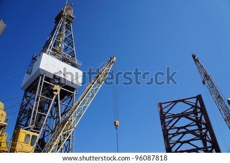 Derick of jack up drilling rig with the rig crane on Sunny Blue Sky Day
