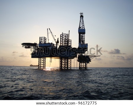 Silhouette of Offshore Jack Up Rig in The Middle of The Sea at Sunset Time