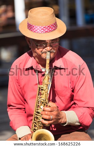 CAPE TOWN, SOUTH AFRICA-OCTOBER, 15: Old man saxophone player at Waterfront performing local music in jazz tone on October 15, 2013 in Cape Town, South Africa.