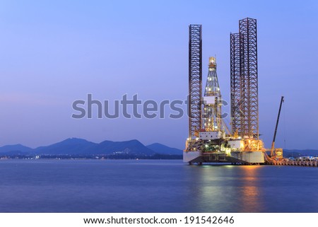 Jack up oil drilling rig in the shipyard for maintenance at sunset time