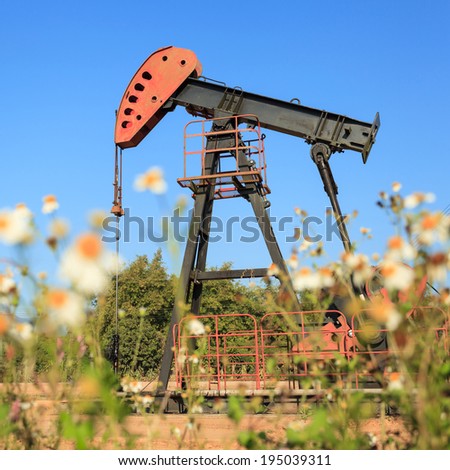 Oil Pump Jack (Sucker Rod Beam) in The Field on Sunny Day
