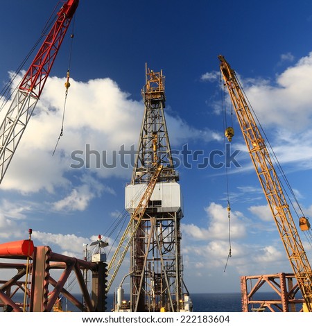 Jack Up Offshore Drilling Rig With Rig Cranes on Sunny Day in The Middle of Ocean