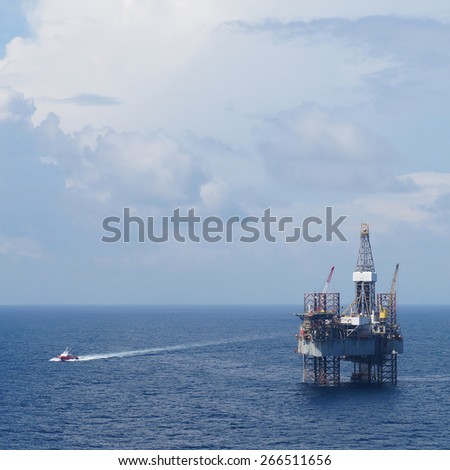 Offshore Drilling Platform (Jack up drilling rig) and crew boat in the middle of the coean