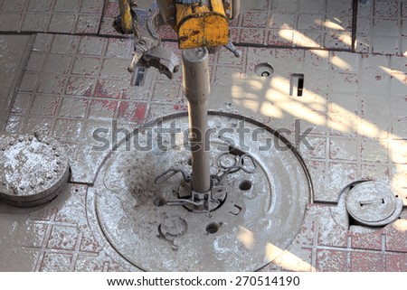 Drill pipe and Top Drive on the rig floor while making up for drilling with dirty water based mud