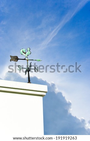 The vintage  wind cock direction on Blue sky cloud and sunlight