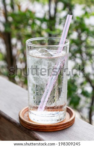 A glass of cold drinking water with tube on relaxing restaurant background