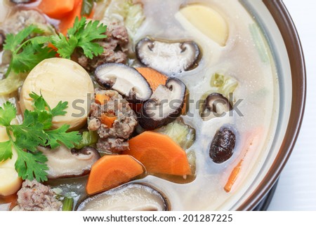Isolated Closeup of Thai and Asian style mushroom soup are mildly seasoned soup that Consisting of pork, tofu, carrots, Chinese Cabbage and mushrooms. good for children and the sick
