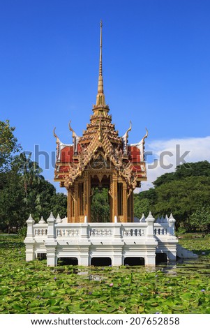 Thai architecture pavilion in water lily flower pond on blue sky cloud in public park