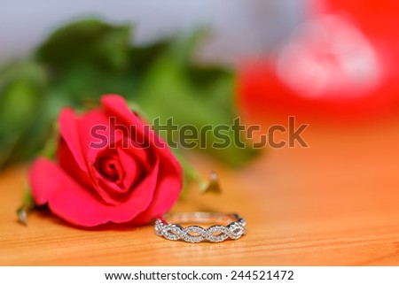 wedding ring and red rose on wood blur and bokeh  for valentine background