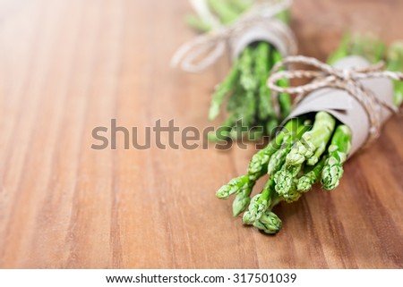 Bunch of fresh asparagus on wooden table for clean food with nature raw material, copy space on the left hand