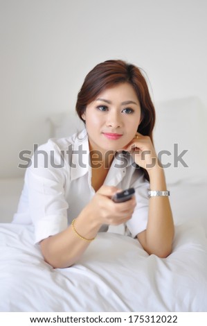woman smile watching tv hold remote control