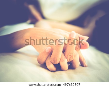 Hands of couple lovers having sex on a bed in morning with lust and love