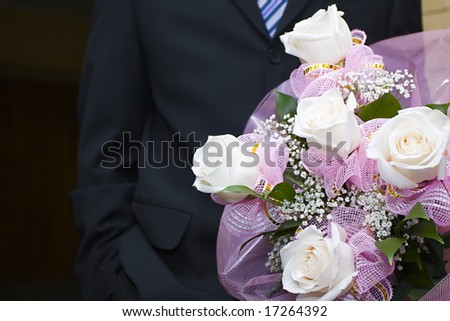 Bouquet in hands of the man in a suit