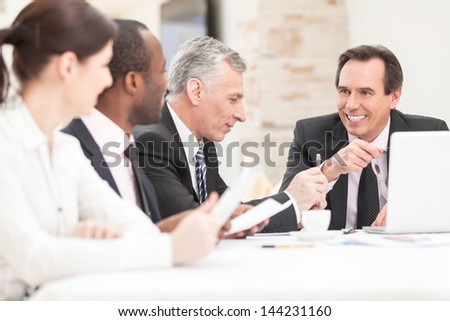 Smiling business people with paper work in board room - staff meeting