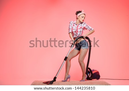 This carpet is so dirty! Sexy young housewife cleaning the carpet with vacuum cleaner and dancing