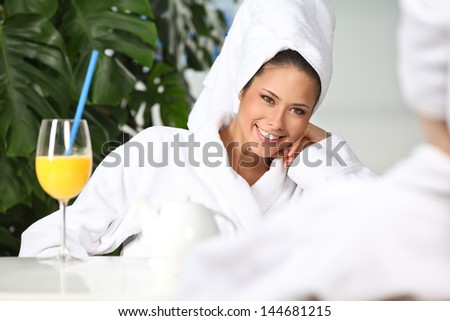 Closeup of pretty smiling woman with juice glass outdoors