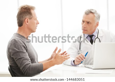 Doctor and patient. Doctor listening to the patient while he is telling about his problems