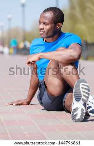 Outdoors exercising. Young african descent men doing his outdoors exercises