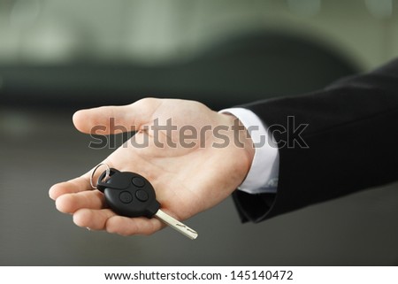 Please, drive carefully! Close up shoot of the hand holding car keys