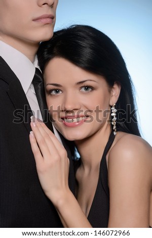 It is a real love. Young couple hugging while standing isolated on blue background