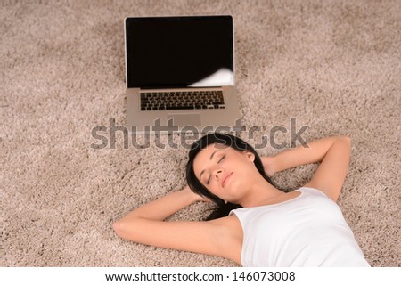 Woman sleeping on the floor. Beautiful yoomen sleeping on the floor at the living room near her laptop