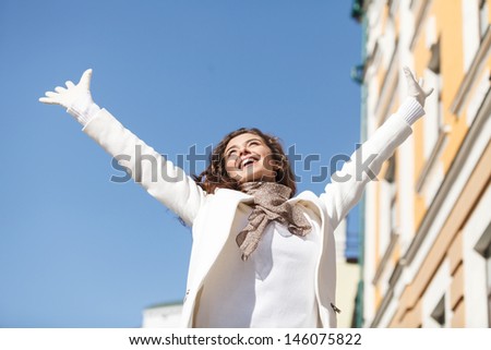 Carefree and happy. Low angle view of happy young women standing with her hands raised up