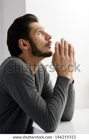 Bearded man praying. Portrait of bearded man praying to god and holding his hands clasped