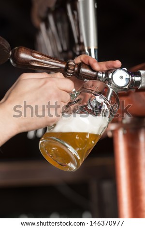 Pouring beer. Close-up of pouring beer at the pub