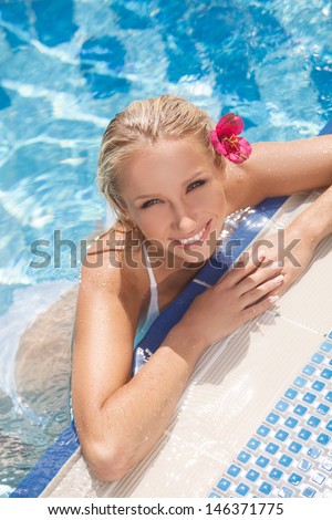 Pretty women in pool. Top view of attractive young women in bikini smiling at camera while standing in pool