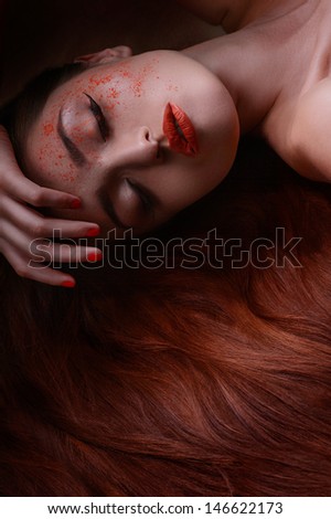 Sleeping beauty. Portrait of beautiful women lying with her hand in hair and face pouring with red powder