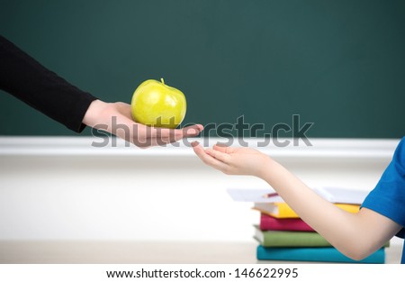 Sharing is good. Close-up of teacher giving an apple to the kid