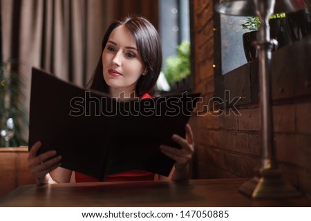 Women reading Menu. Beautiful middle-aged women reading Menu at the restaurant