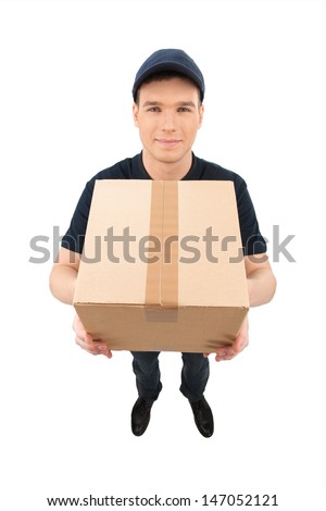 Just in time. Top view of cheerful young deliveryman stretching out the cardboard box and smiling while isolated on white