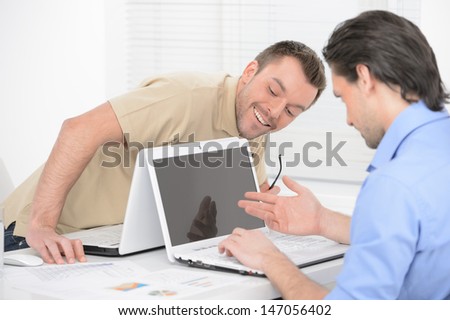 Outstanding news. Two cheerful business people looking at the computer monitor and smiling