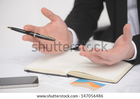 Businessman gesturing. Close-up of businessman gesturing with a pen in his hand